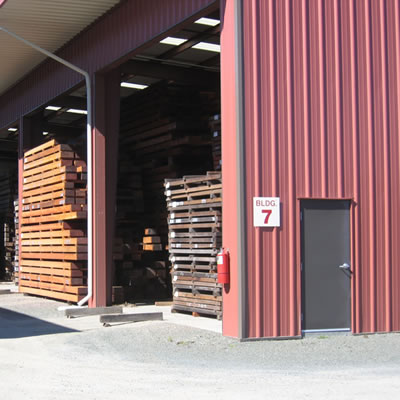 Covered storage protecting redwood lumber products.