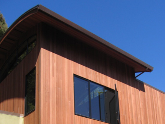 Redwood siding with a curved roof on a contemporary home.