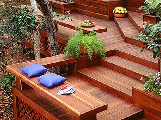 A multi-level deck, with steps and built-in benches, made from redwood lumber.