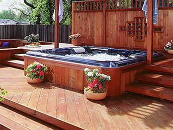 Redwood deck, steps and fence surround a backyard spa.